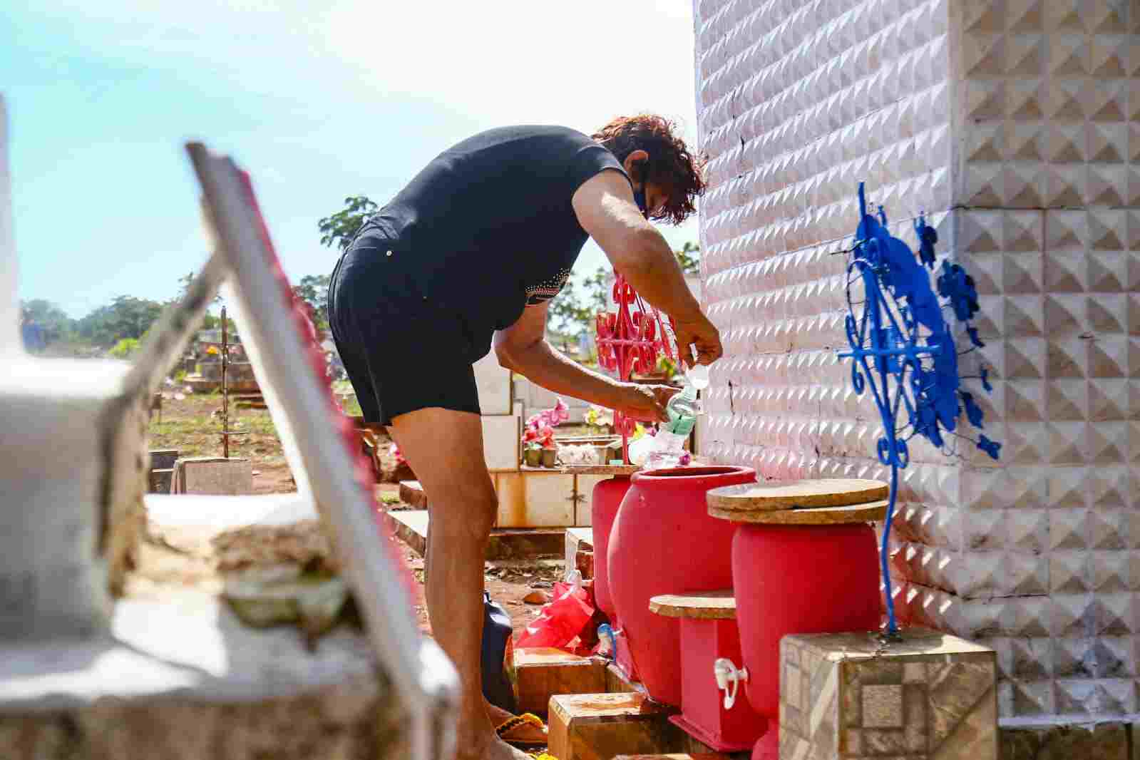 Devota levou água e até "tomou banho" no local com o líquido (Foto: Marcos Ermínio, Midiamax)