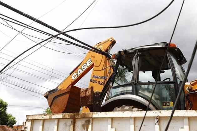 Retroescavadeira carregada por caminhão derruba postes e deixa rua sem energia em Campo Grande