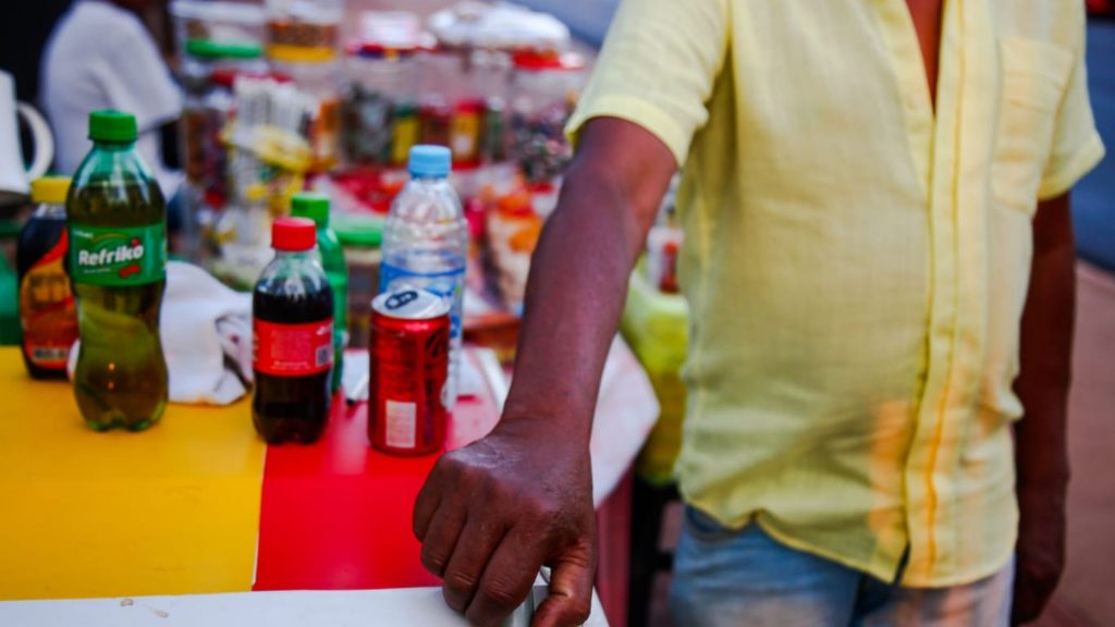 Idoso vende bebida e doces na rua