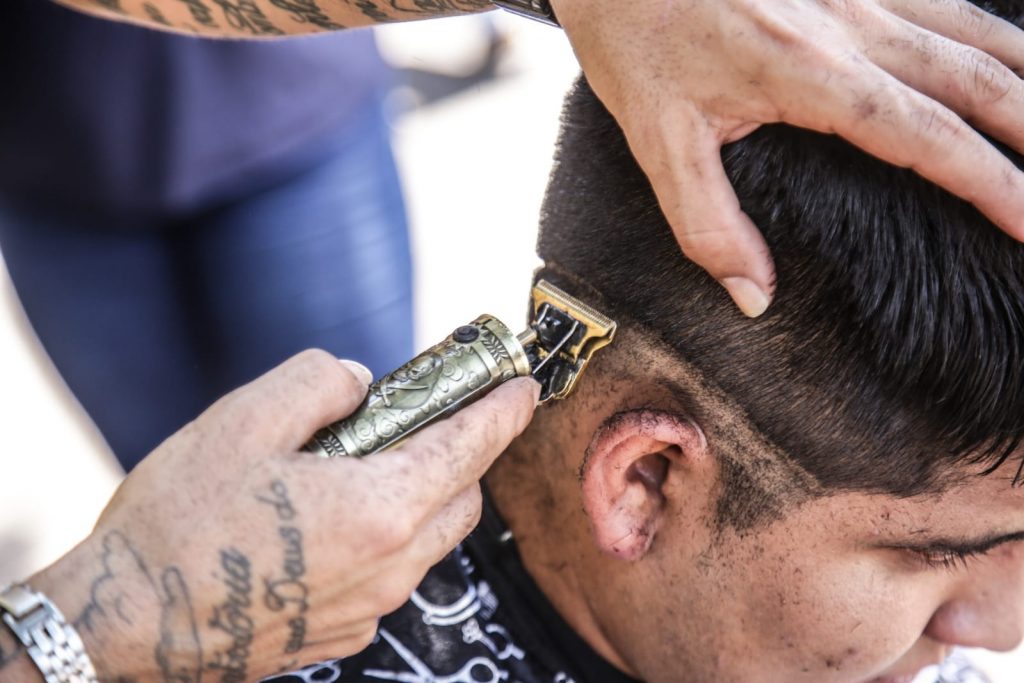 Barbeiro cortando cabelo de cliente no Centro de Campo Grande. Foto: Henrique Arakaki/Jornal Midiamax