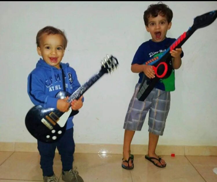 Eros e Lorenzo brincando com instrumentos musicais. Foto: Alessandra Azevedo/Arquivo Pessoal