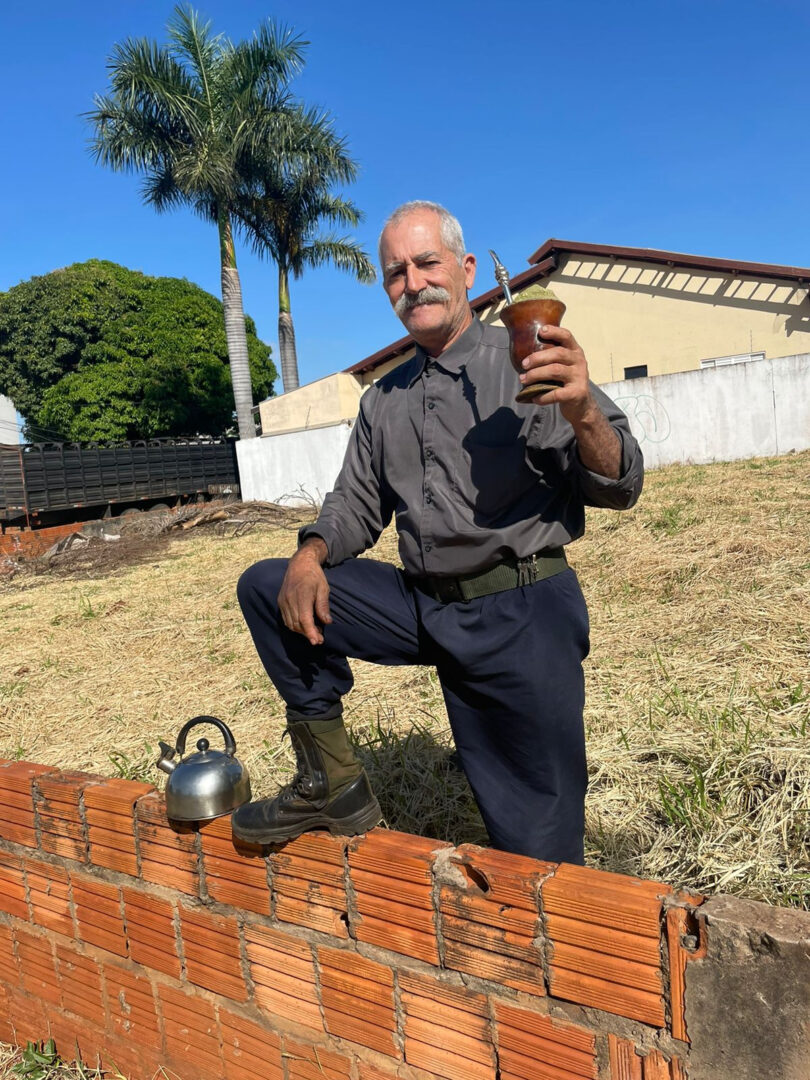 Ao levar buzinadas, Joaquim levanta chimarrão e diz: 'Grande dia'. Foto: Graziela Rezende/Jornal Midiamax